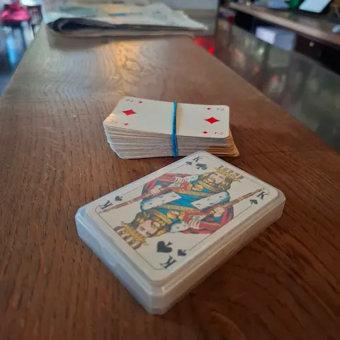 Two card games laid out on the wooden bar in the cozy Sowiso Ocean Bar in Aachen